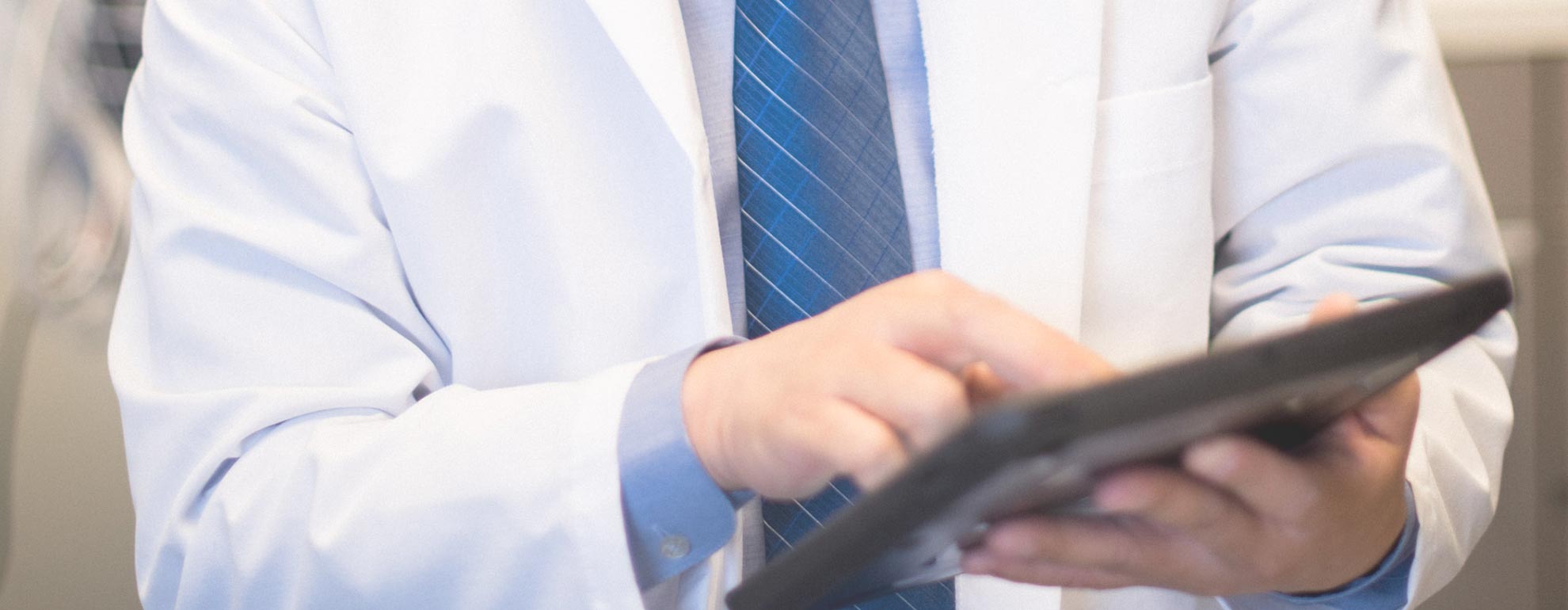 Close-up of physician using a tablet.