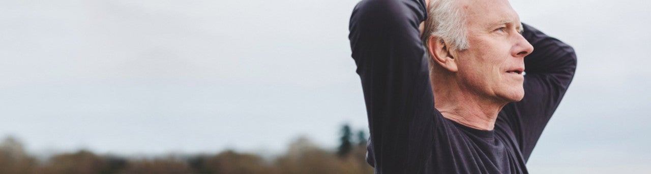 Man holding his hands over his head after a workout 