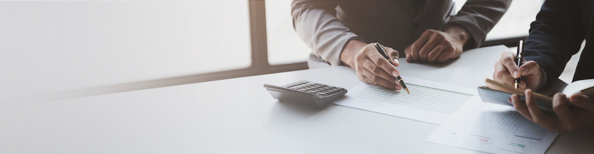 Closeup of two business professionals working on financials.