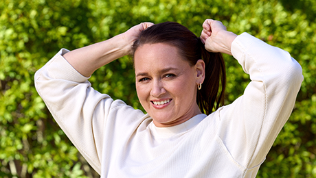 Mujer sonriendo agarrando su cabello