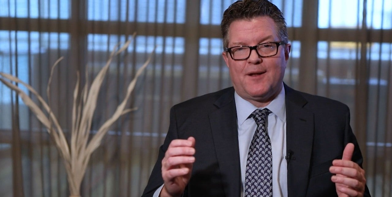 Still from Video. Dr. Collins sitting discussing treatment outcomes. 