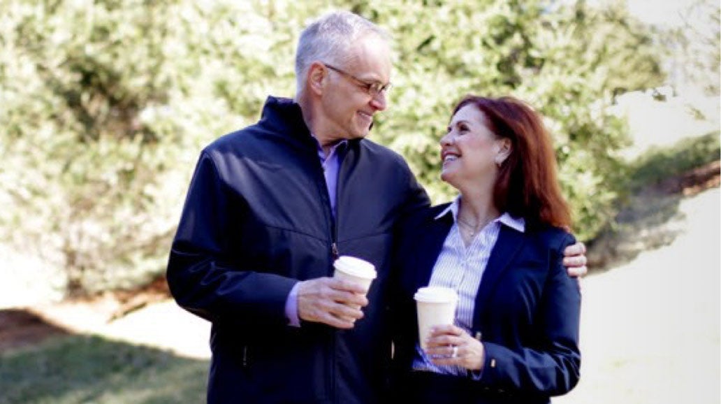 happy couple embracing and drinking coffee