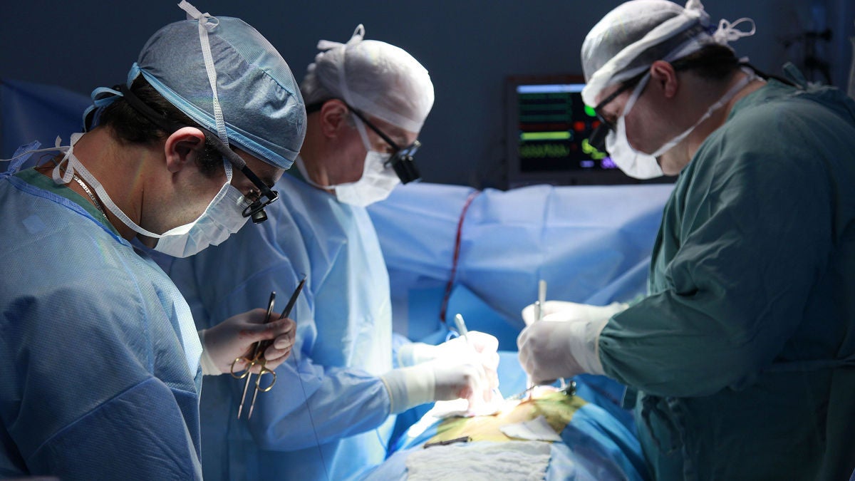 Three physicians in an operating room.