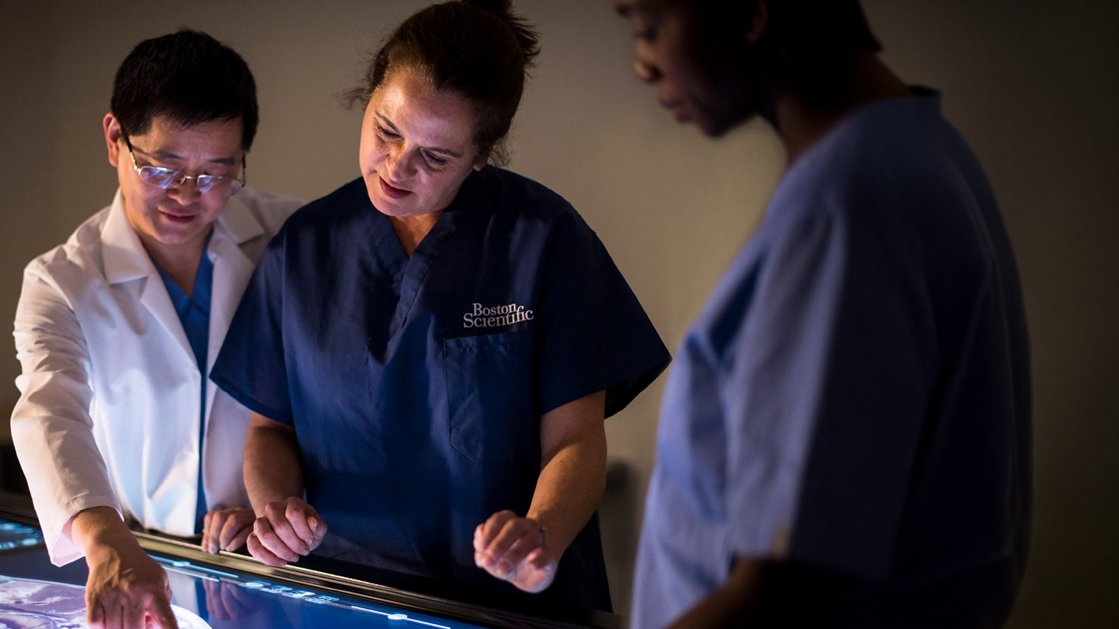 Healthcare provider discussing over large monitor.