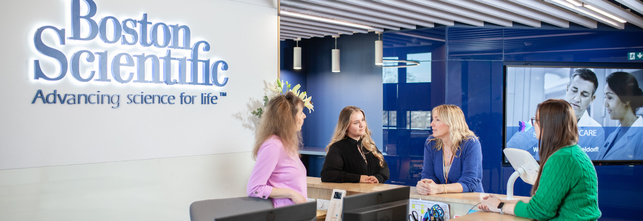 Boston Scientific employee smiling in a break area with green plants in the background