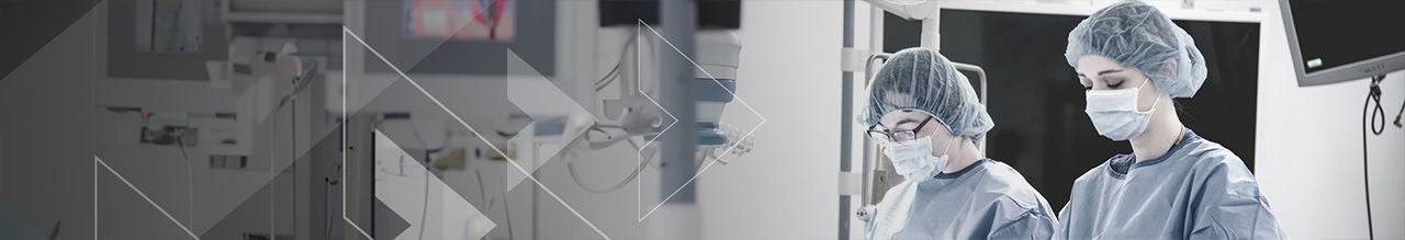 two women with face mask in lab coat with head cap.