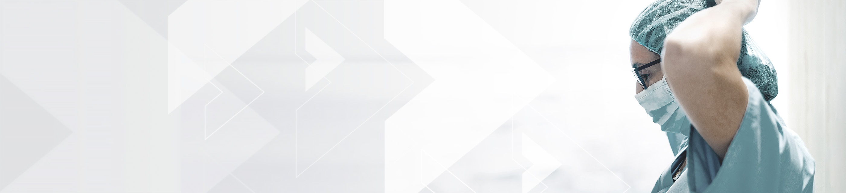 Medical professional wearing surgical cap and tying surgical mask.