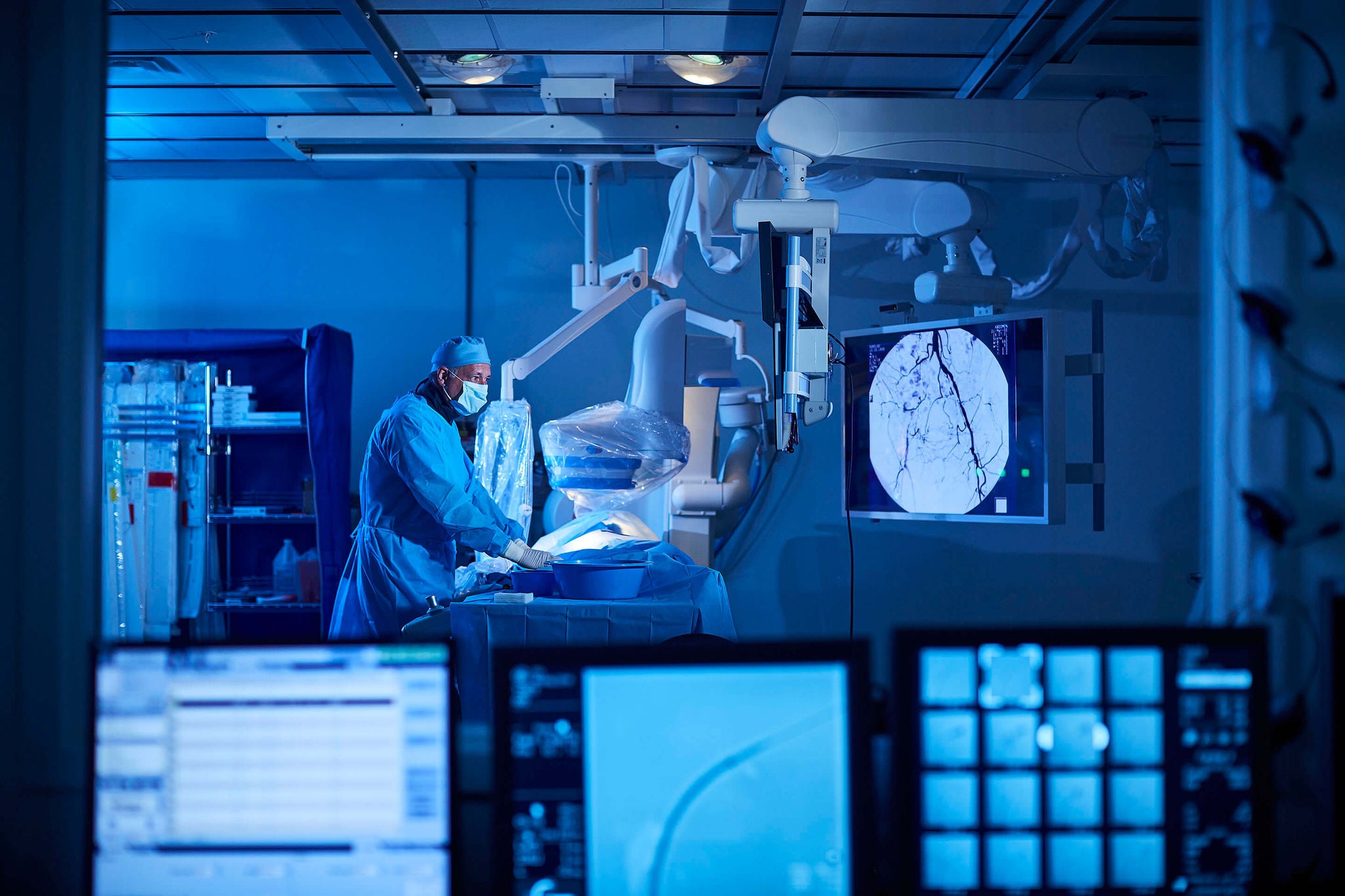 View of a healthcare professional performing surgery from a control room. 