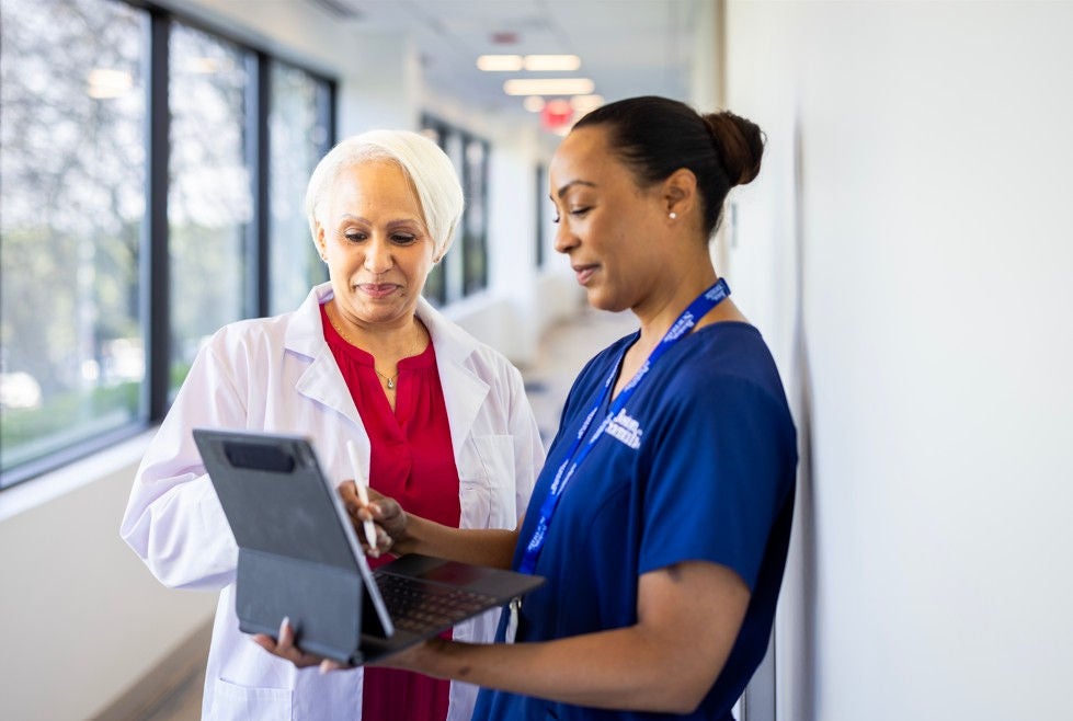 Healthcare providers collaborating on laptop.
