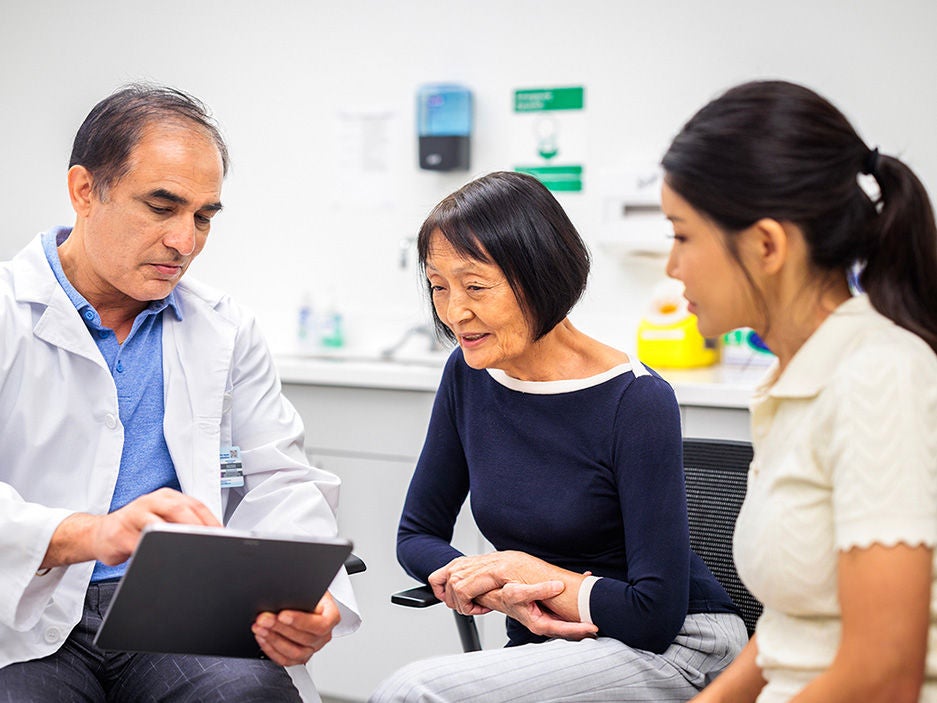 Physician talking to an older woman and her daughter.