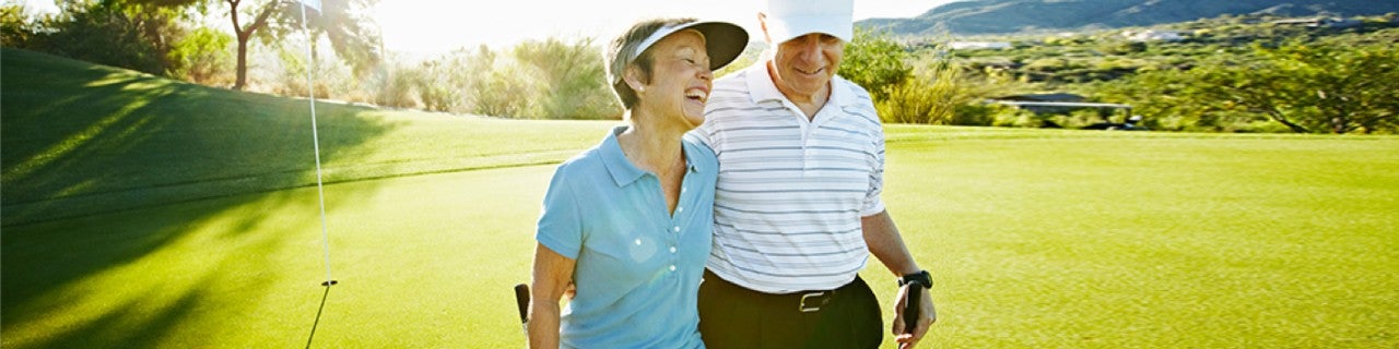 Two people walking on a golf course 