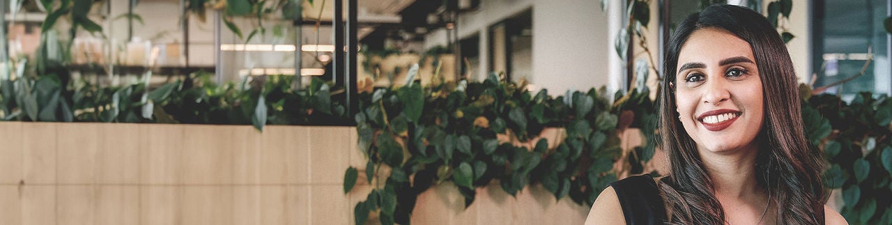 Boston Scientific employee smiling in a break area with green plants in the background