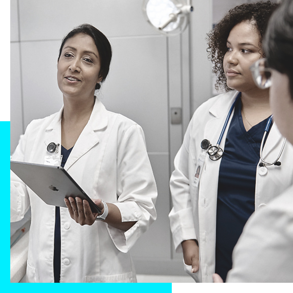 Volunteers wearing Boston Scientific t-shirts pose with a doc while smiling into the camera.