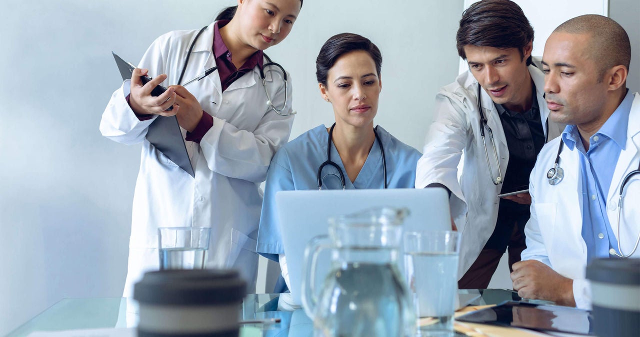 Four urology specialists in a hospital setting.