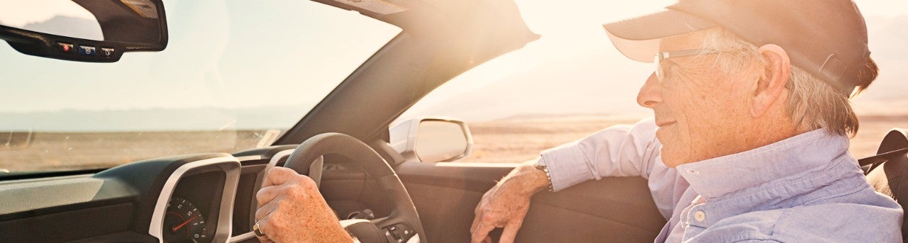 Man driving in a convertible.