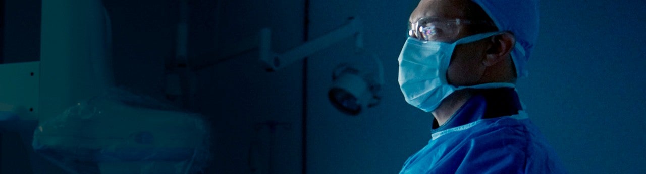 Medical staff member in mask viewing a monitor