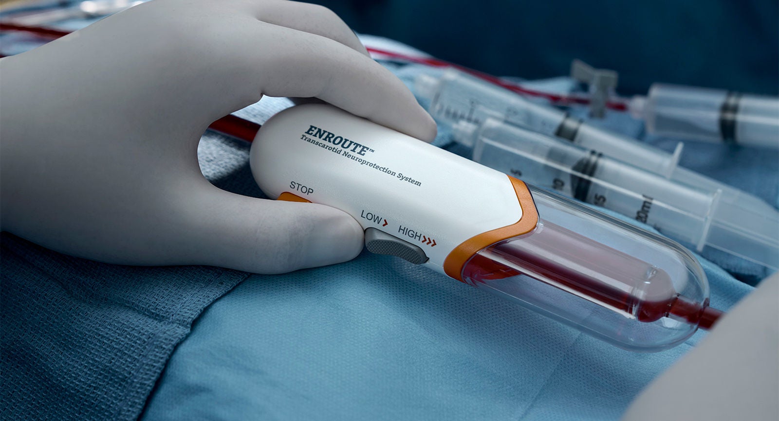Healthcare professional reversing blood flow with the use of the Enroute Transcarotid Neuroprotection System during a carotid artery stenting procedure.