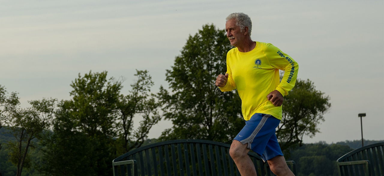 Old men running in yellow Tshirt and blue shorts.