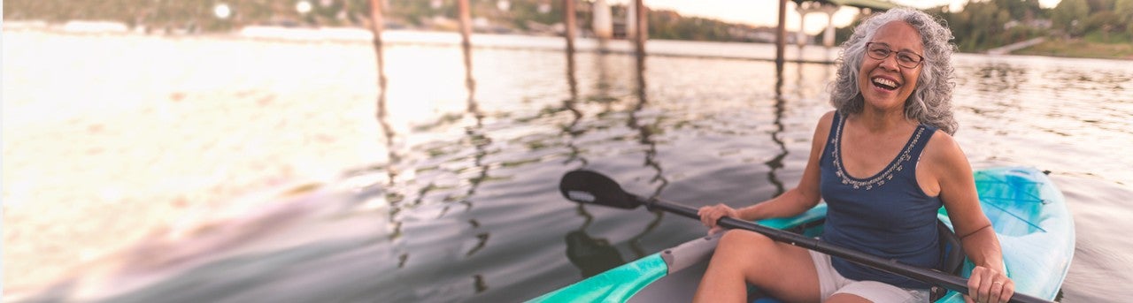 Woman smiling and paddling in a kayak