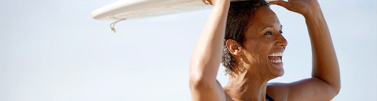 Woman holding a surfboard over her head          