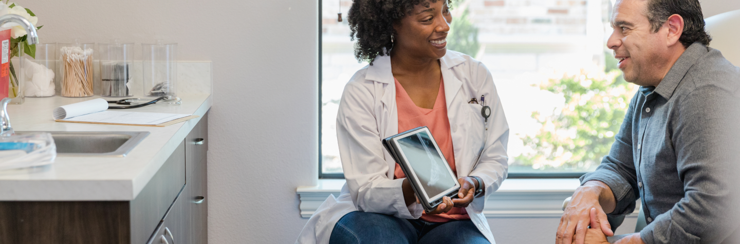 Female doctor holding ipad in front of patient.