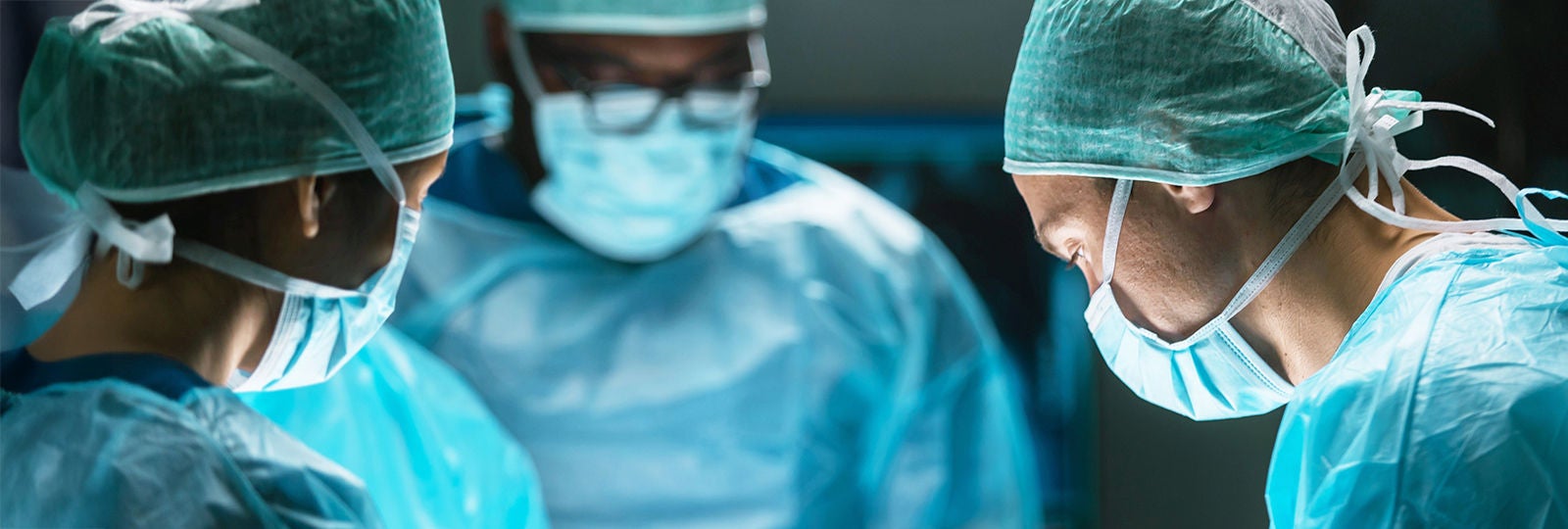 Woman in lab coat and protecting cap with eye glasses.
