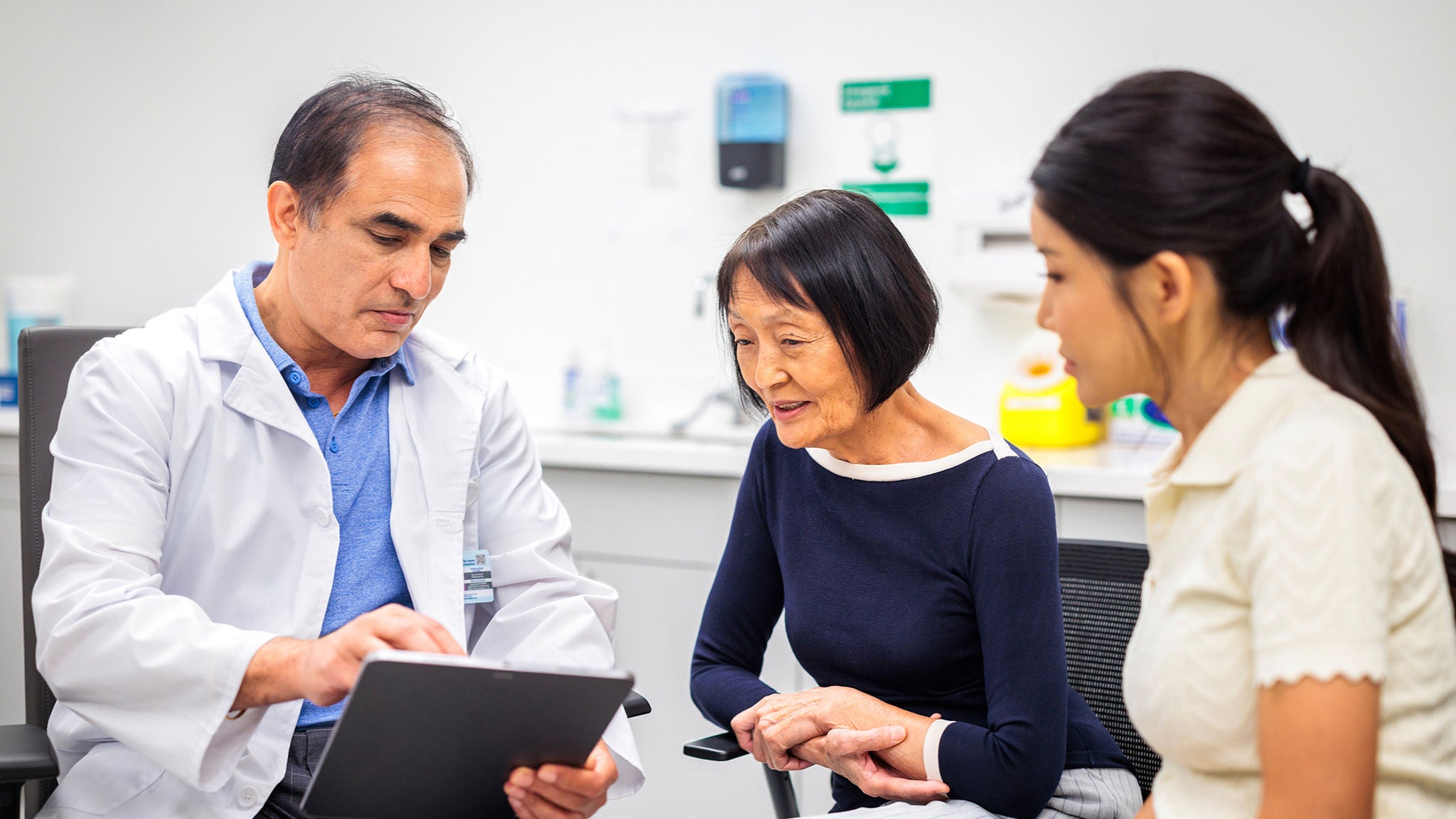Physician talking to an older woman and her daughter.