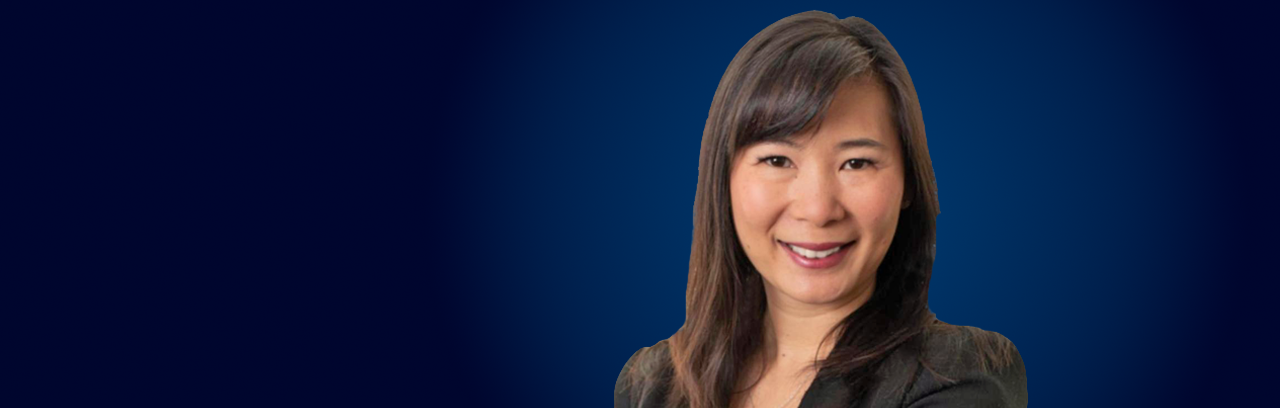 Headshot of Katie Liao in black coat and smiling face.