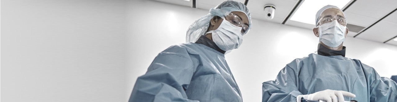 Two doctors in surgical scrubs and masks, in a hospital.