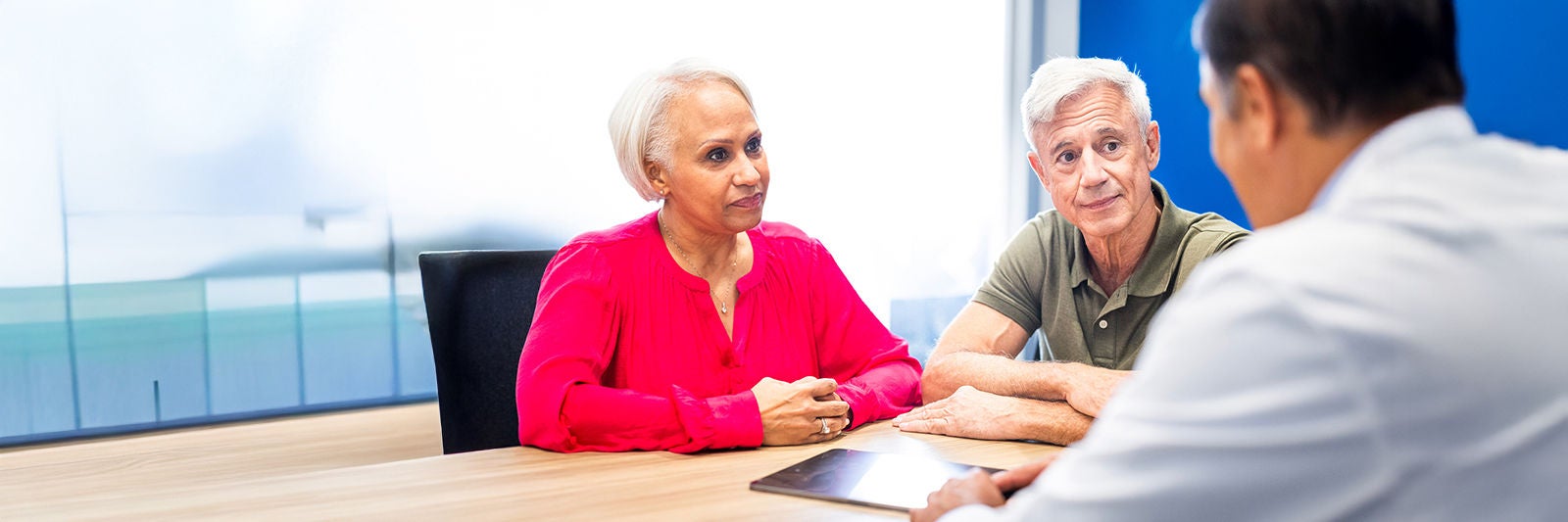 Man and woman seated listening to a physician.