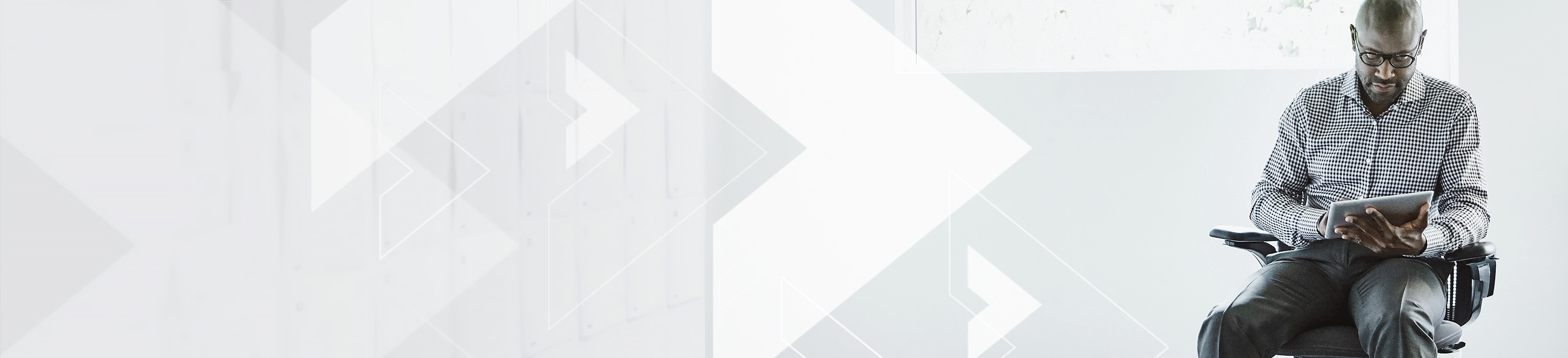 Man sitting in chair using tablet.