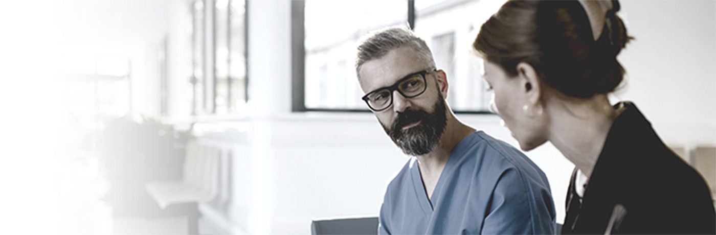 Healthcare provider and administrator talking with each other.