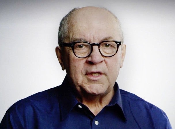 Man in glasses speaking straight ahead