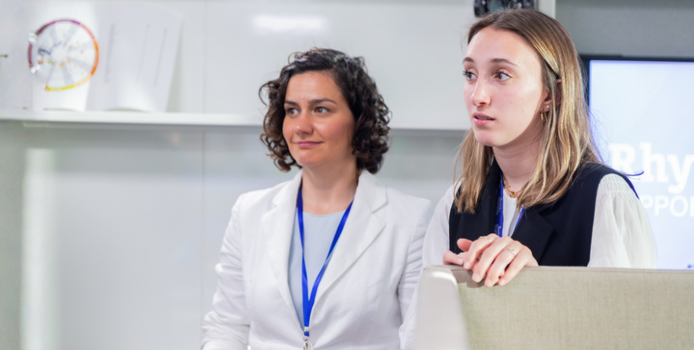 Dos jóvenes empleadas de Boston Scientific asisten a una presentación en la oficina de Madrid con expresión de interés