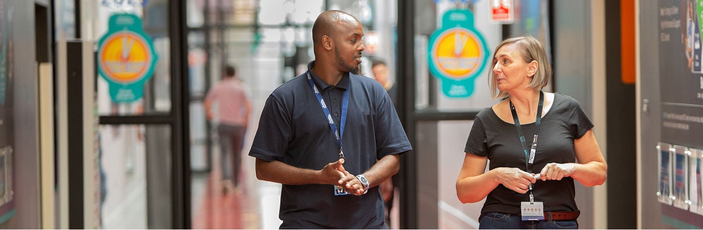 Employees walking through a corporate facility, supporting a connected and collaborative work environment.