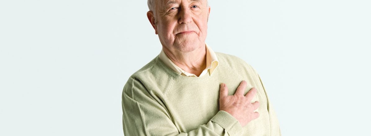 Man gripping his chest over his heart