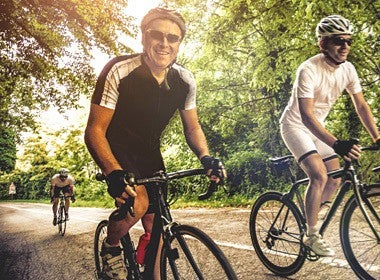 Three men biking on a road 