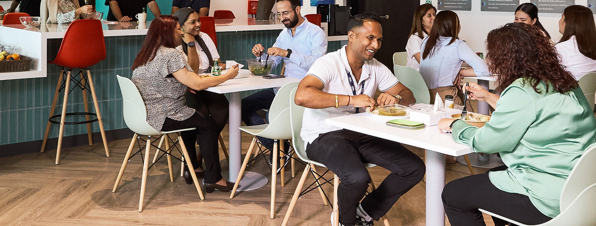 A group of  Boston Scientific employee inside office common area smiling and talking with each other.