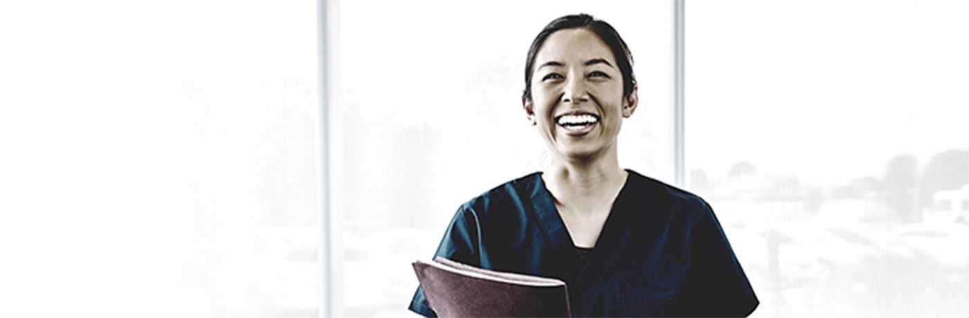 Smiling healthcare provider holding folder.