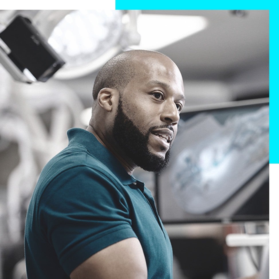 Volunteers wearing Boston Scientific t-shirts pose with a doc while smiling into the camera.