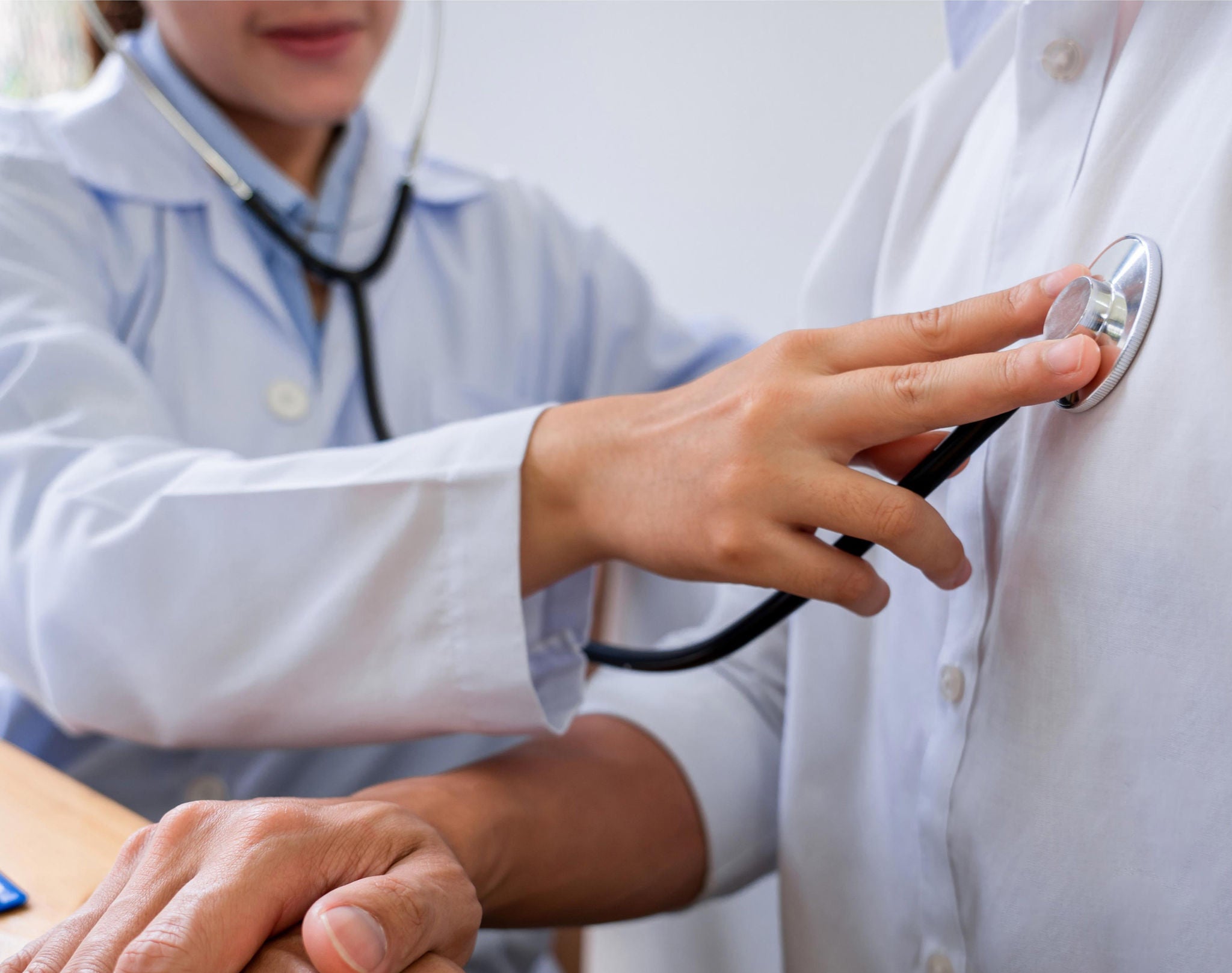 Doctor using stethoscope on patient