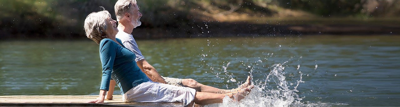 Two people sitting on a dock 
