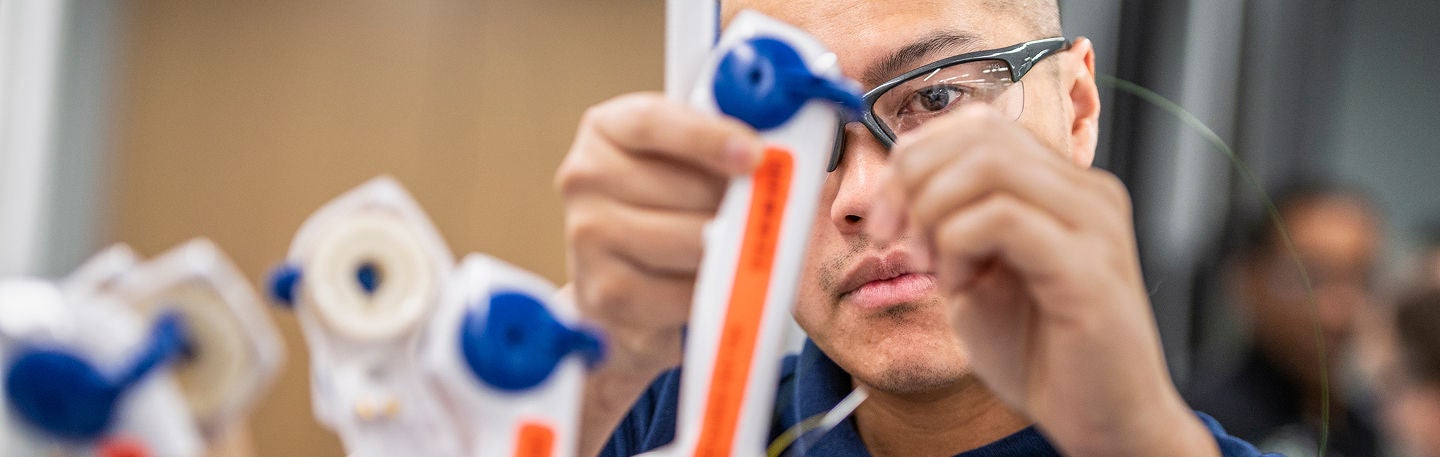 Manufacturing employee inspecting products to ensure quality, safety, and operational excellence.