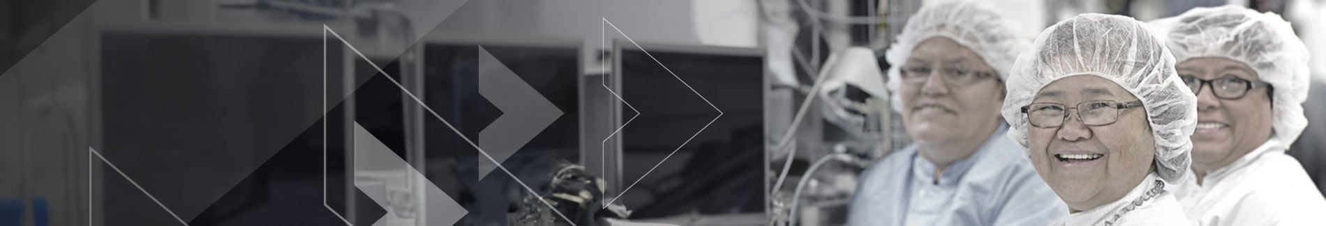 Group of smiling people wearing protective head cap looking toward camera.