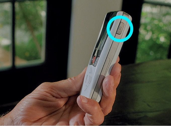 Person holding remote with the right hand unlock button highlighted