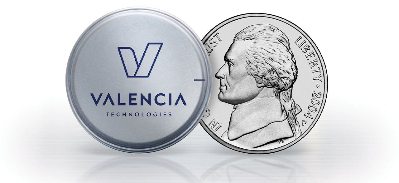 A small circular Valencia Technologies device is displayed next to a United States nickel coin.