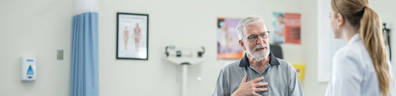 Senior patient speaking with healthcare professional during a hospital consultation appointment