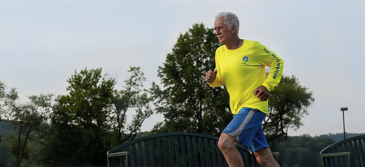 Older man running in yellow shirt.