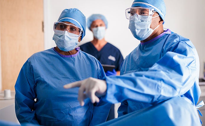 group of three physican wearing protective glassand lab coat inside clinic