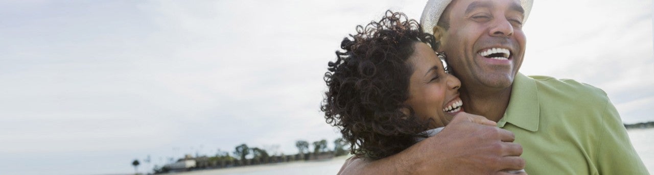 Husband and wife embracing on a beach     